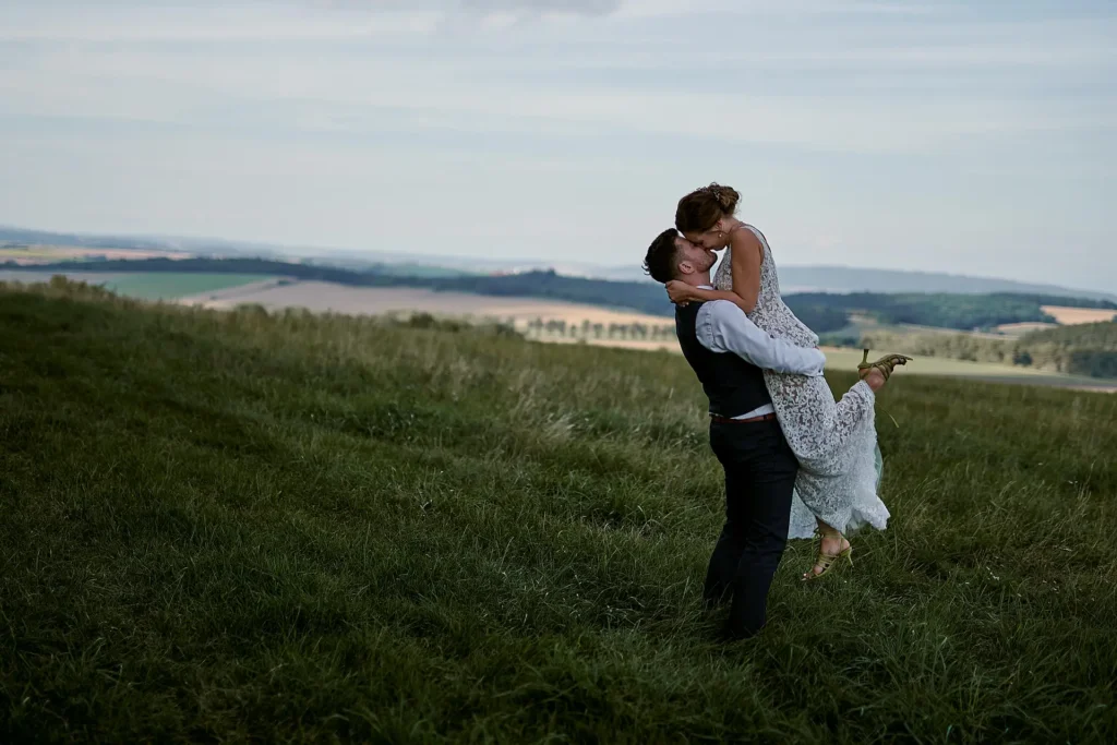 Přirozený svatební portrét páru v exteriéru s polibkem na poli Olomouc